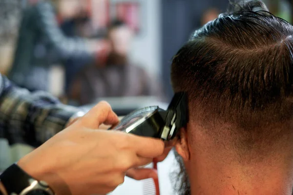 Maestro corta el pelo y la barba de los hombres en la barbería Fotos De Stock Sin Royalties Gratis