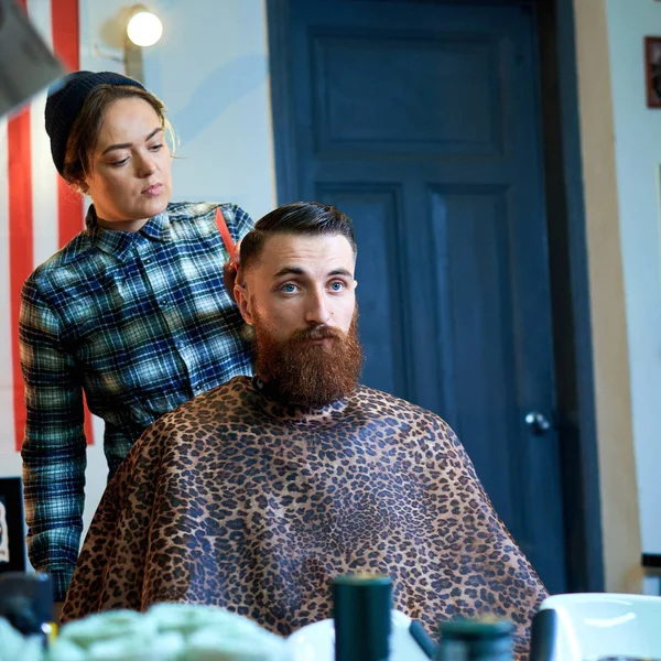 Maestro corta el pelo y la barba de los hombres en la barbería Imágenes De Stock Sin Royalties Gratis