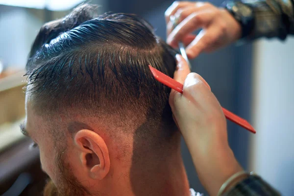 Maestro corta el pelo y la barba de los hombres en la barbería Imágenes De Stock Sin Royalties Gratis