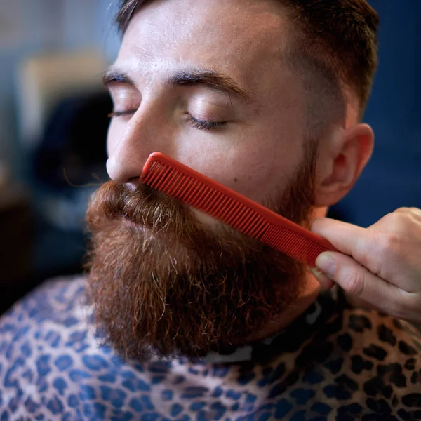 Master cuts hair and beard of men in the barbershop — Stock Photo, Image