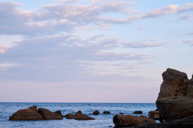 Deniz dalgaları taşların üzerinde yuvarlanıyor