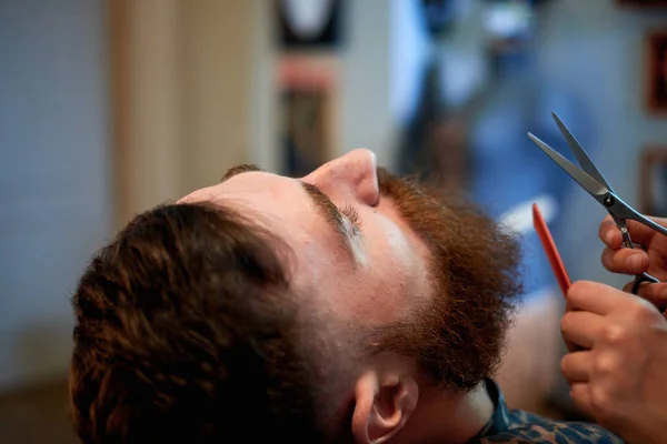 Maestro corta el pelo y la barba de los hombres en la barbería Imagen De Stock