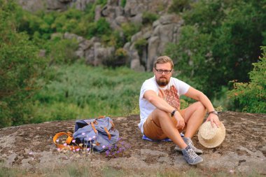 Kanyon cliff üzerinde oturan bir sakallı genç adam