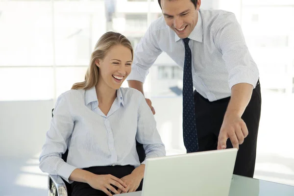 corporate business training - businessman working with pretty woman on laptop in office