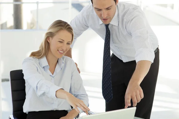 corporate business training - businessman working with pretty woman on laptop in office