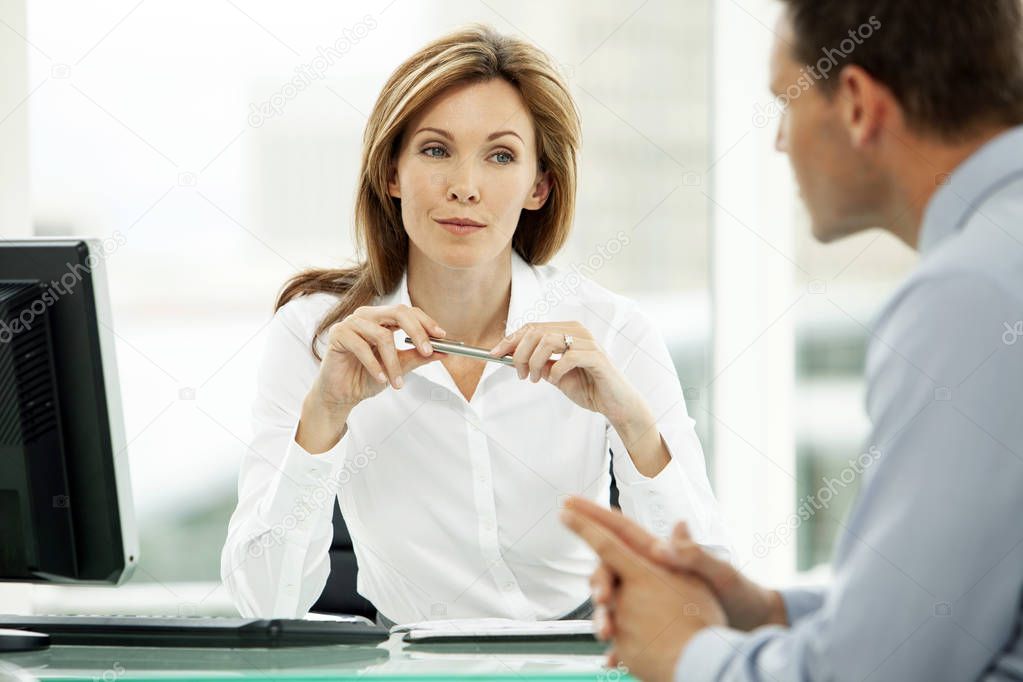 corporate business executive woman listening to young businessman in office