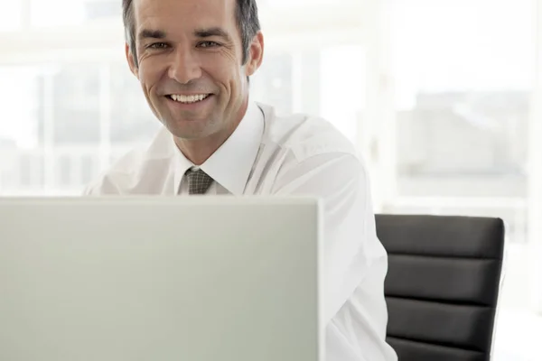 微笑的商人在办公室工作在笔记本电脑 — 图库照片
