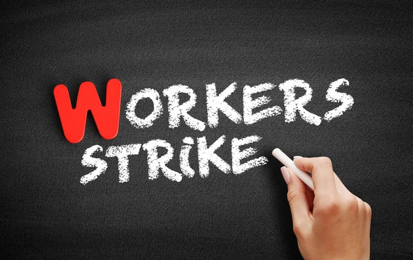 Workers strike text on blackboard
