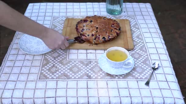White table with a pie, tea cup and . Wooman — Stock Video