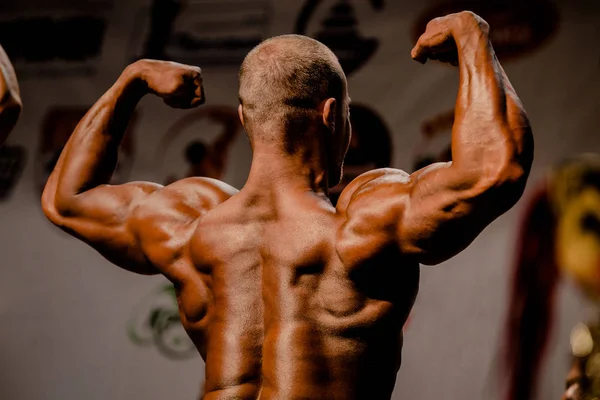 man athlete bodybuilder pose back double biceps