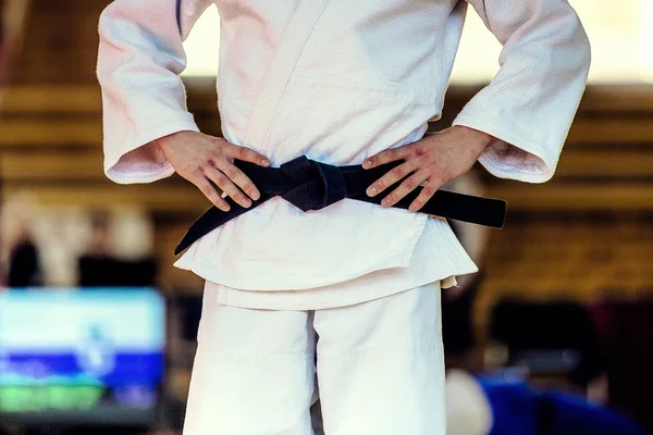 closeup athlete judoka in white kimono and black belt