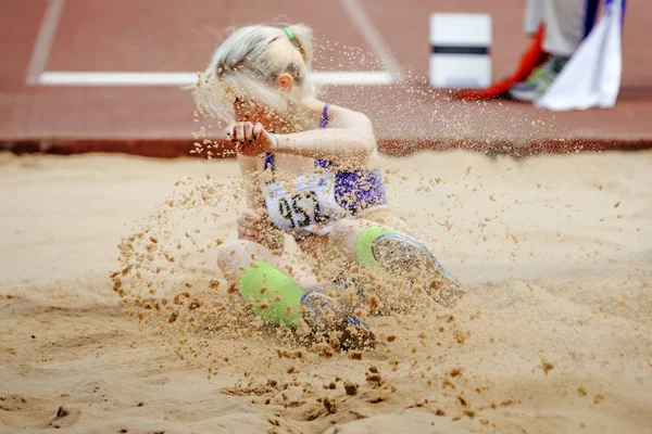 competition long jump women landing in sand a spray