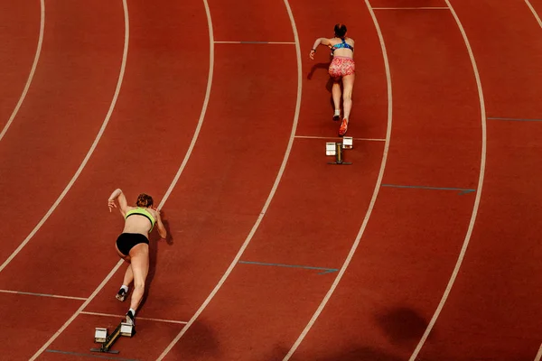 back two women runners start race at 400 meters in competition