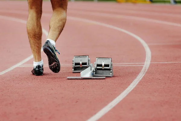 feet men runner sprinter track and starting blocks