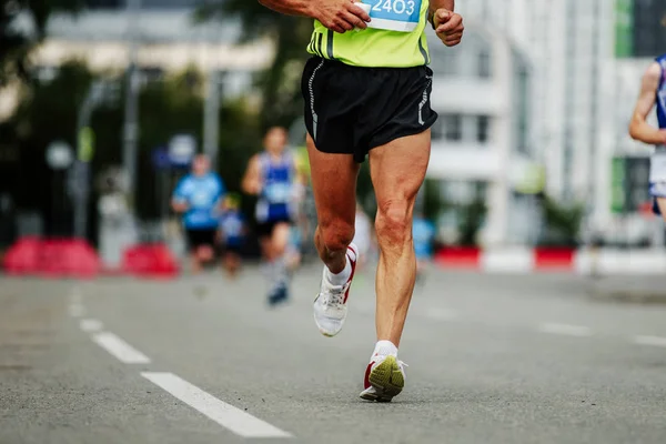 runner middle-aged man running down street marathon city