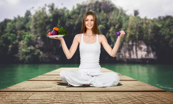 Kadın Iskelede Oturan Yoga Yapıyor Sebze Ile Dambıl Tabak Tutarak — Stok fotoğraf