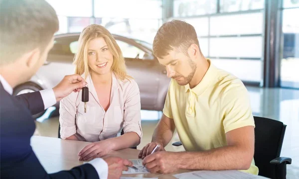 Gelukkige paar met autohandelaar — Stockfoto