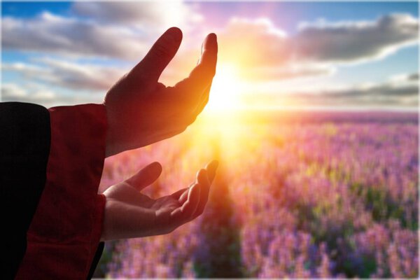 Hands of human praying on sunset backgroun