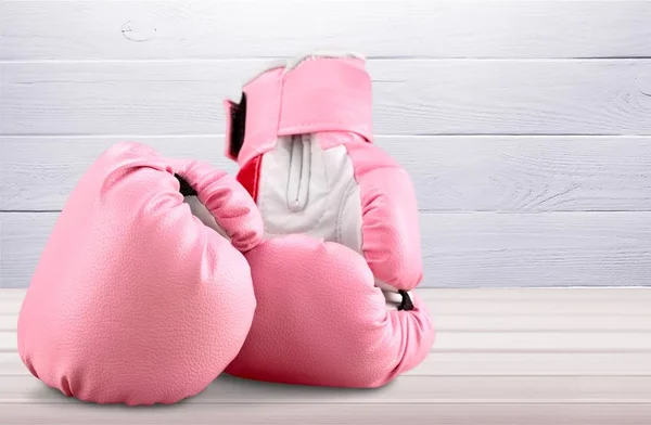 Pink boxing gloves on wooden table