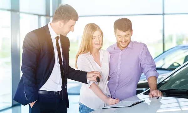 Gelukkige paar met autohandelaar — Stockfoto