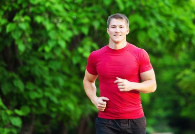 Yeşil Park'ta koşan genç yakışıklı sportif adam