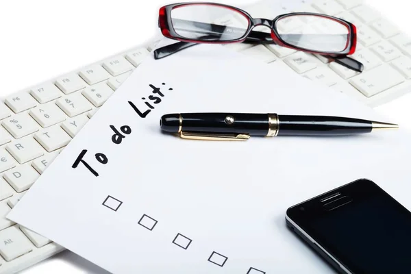 Cell phone, pen and glasses on top of a to do list — Stock Photo, Image