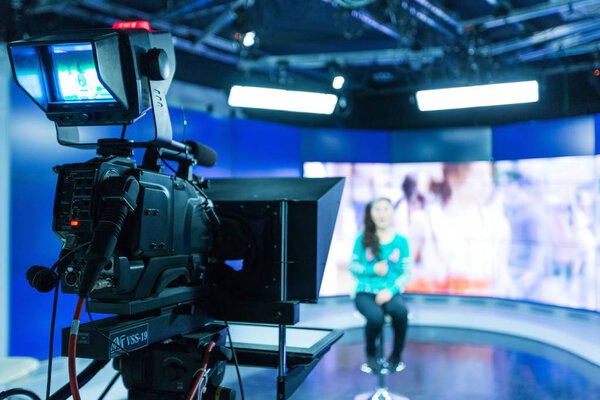 Closeup of a Video Camera Filming a TV Host