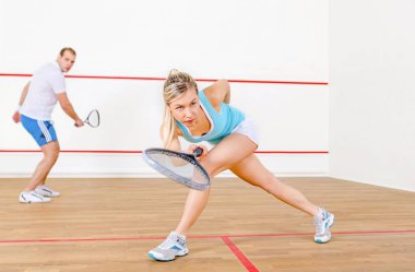 mutlu genç adam ve kadın squash oynuyor 
