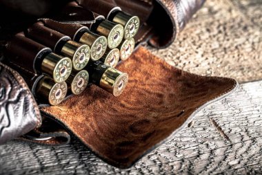 eski avcılık kartuşları ve ahşap bir masaya bandoleer