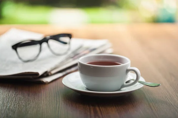 Gazety, czytanie okulary coffee cup. — Zdjęcie stockowe