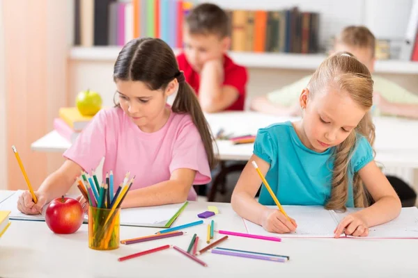 Los niños de la escuela en el aula de escritura / dibujo — Foto de Stock