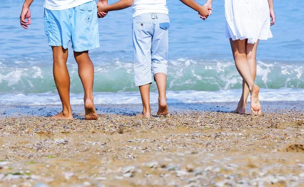 손을 잡고 걷는 낭만적인 해변 휴가 몇 모래에 발자국을 떠나는 휴가 여행. 발과 복사 공간에 대 한 황금 모래의 근접 촬영. 흰색 반바지를 입고 젊은 부부 — 스톡 사진