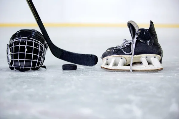 Хоккейный шлем, шайба, клюшка и коньки на катке — стоковое фото