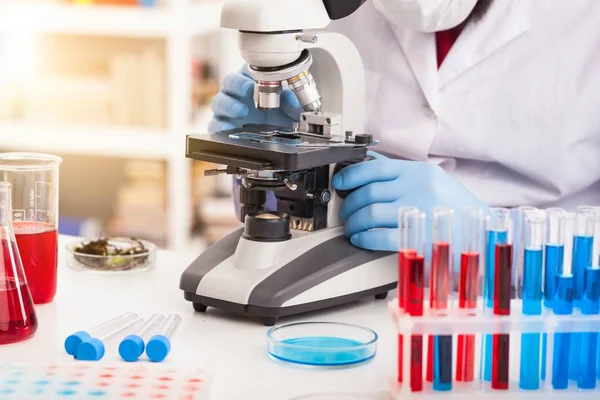 Hombres en un microscopio de laboratorio . — Foto de Stock