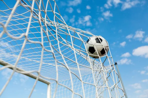 Una pelota de fútbol en una red — Foto de Stock