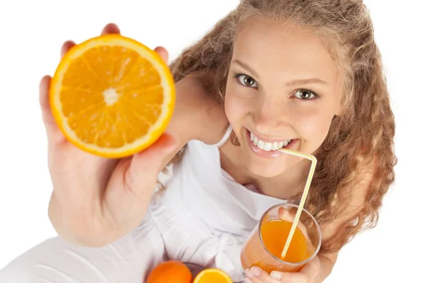 Młoda kobieta pije sok pomarańczowy pokazując pomarańczowy portret — Zdjęcie stockowe
