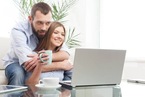 Cheerful young couple working on laptop. — Stock Photo, Image