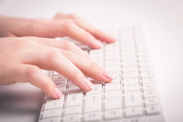 Hands typing on keyboard on modern laptop