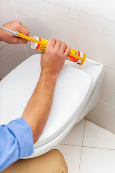 Close up van een loodgieter tot vaststelling van de wc. — Stockfoto