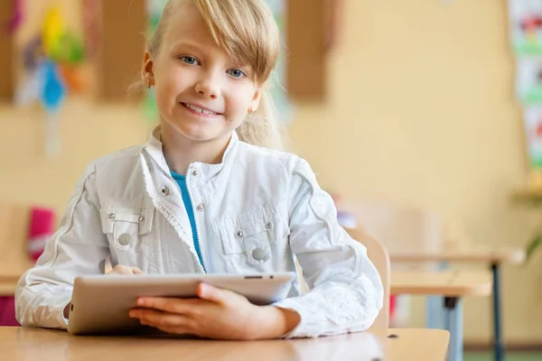 Sonriente joven en un aula usando una tableta — Foto de Stock