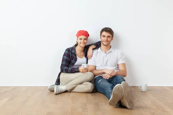 年轻夫妇坐在地板上的空房间 — 图库照片