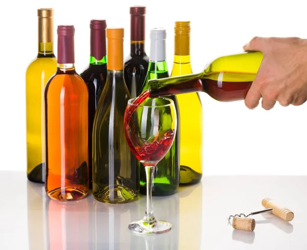 Χύνοντας κόκκινο κρασί σε ποτήρι και μπουκάλια κρασιού — Φωτογραφία Αρχείου