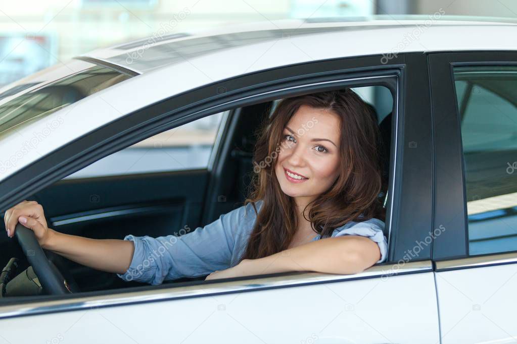 Young happy woman in car 