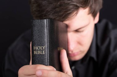 Portre bir İncil ile dua genç bir adam üzerinde