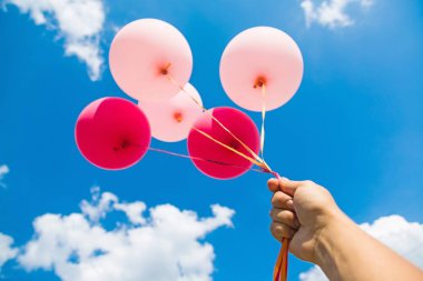 Balonlar mavi gökyüzü arka plan üzerinde tutan el