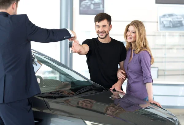 happy couple with car dealer
