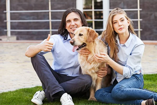 Pareja feliz en el jardín con perro —  Fotos de Stock