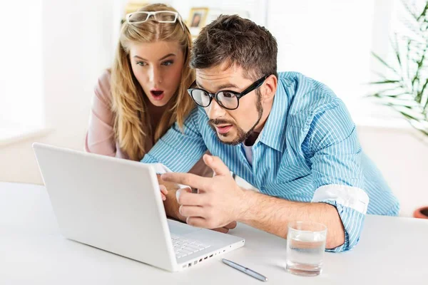 Twee verrast studenten leren in bibliotheek op laptop — Stockfoto