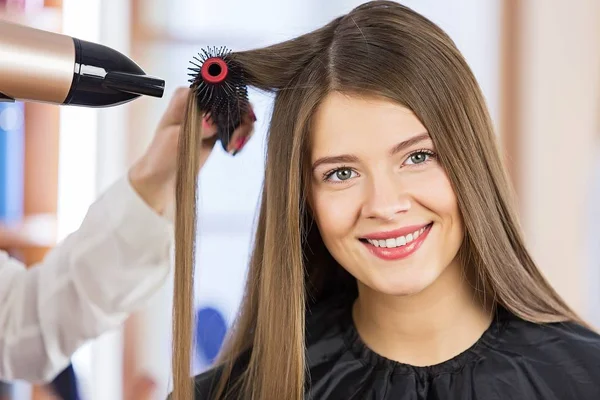 Frauenporträt Föhnen der Haare im Schönheitssalon. — Stockfoto