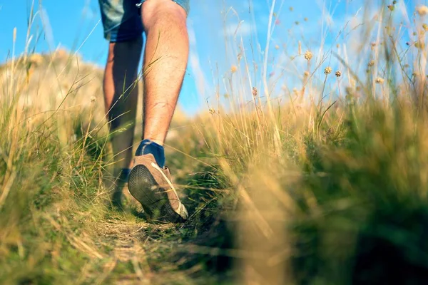 Detailní záběr na Mans nohy chůze přes pole — Stock fotografie